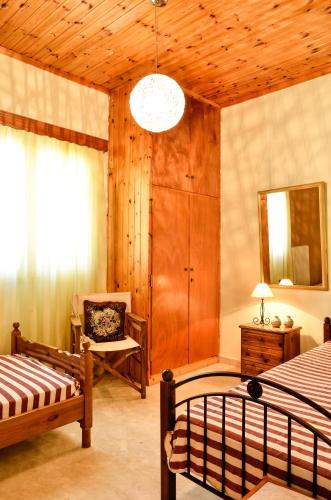 a bedroom with two beds and a chair and a mirror at Doloi garden house in Málta
