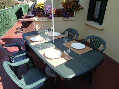 a blue table with plates and wine glasses on it at Maison Baxter in Prats-de-Mollo-la-Preste