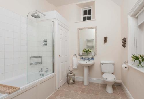 y baño con aseo, lavabo y ducha. en Manor Cottage en Whitby