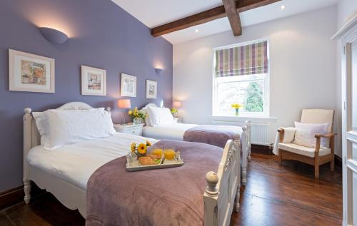 a bedroom with two beds and a tray of fruit at Mews Cottage in Whitby