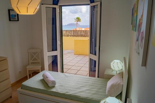 a bedroom with a bed and a view of a patio at Porto Santo Blue House in Porto Santo