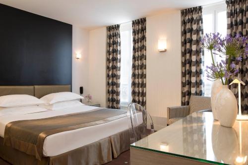 a hotel room with a bed and a table at Hôtel A La Villa des Artistes in Paris