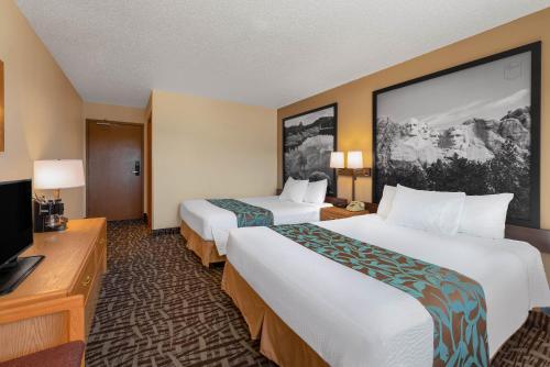 a hotel room with two beds and a flat screen tv at Super 8 by Wyndham Hill City/Mt Rushmore/ Area in Hill City