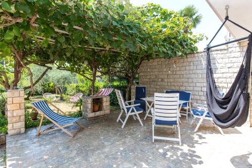 a patio with chairs and a table and hammocks at Casa Flora 3-minutes’ walk from the beach in Novigrad Istria