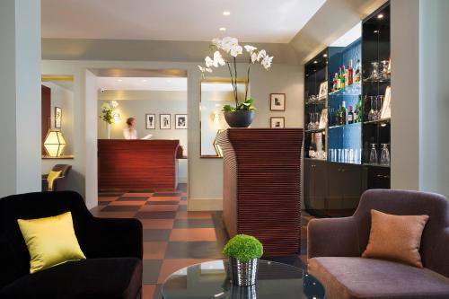 a lobby with two chairs and a reception desk at Hôtel A La Villa des Artistes in Paris