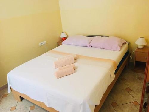 a bedroom with a bed with two towels on it at Apartmani Djura in Selce