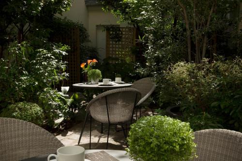 a patio with chairs and a table in a garden at Hôtel A La Villa des Artistes in Paris