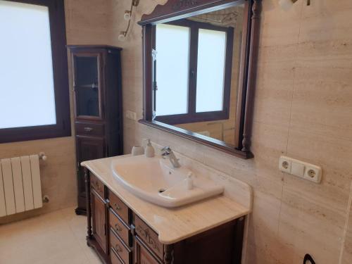 een badkamer met een wastafel en een spiegel bij Alojamiento El Olivo in Ronda