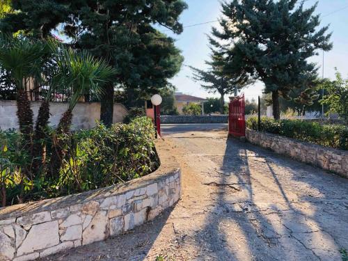 a red phone booth in a park with trees at A casa di nonna Lina in Polignano a Mare