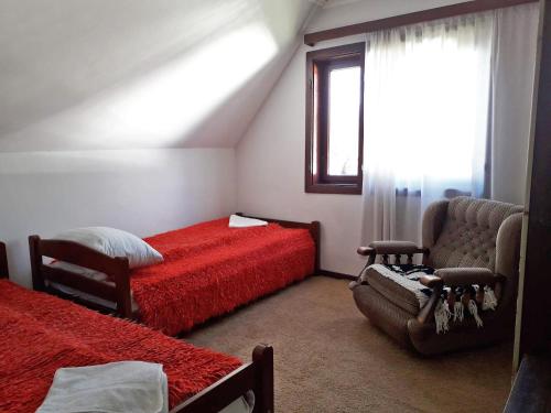 1 dormitorio con 2 camas, silla y ventana en Old Guest House 1964, en Žabljak