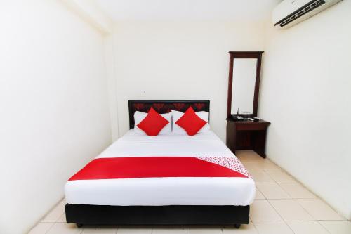 a bedroom with a bed with red pillows and a mirror at Green Palace Colombo in Colombo