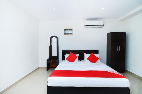 a bedroom with a bed with red pillows at Green Palace Colombo in Colombo