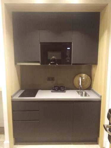 a small kitchen with a microwave and a sink at Apartamentos Ardales Premium in Ardales