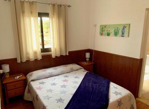 a small bedroom with a bed and a window at La Finca de Los Padres in Tefía