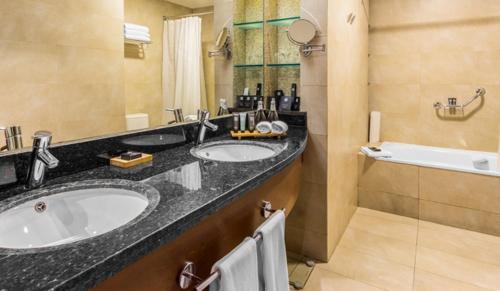a bathroom with two sinks and a bath tub at MDS Hotel Concepción in Concepción
