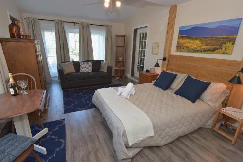 1 dormitorio con cama, sofá y mesa en Chez Les Bergeron, en Saint Aime Des Lacs