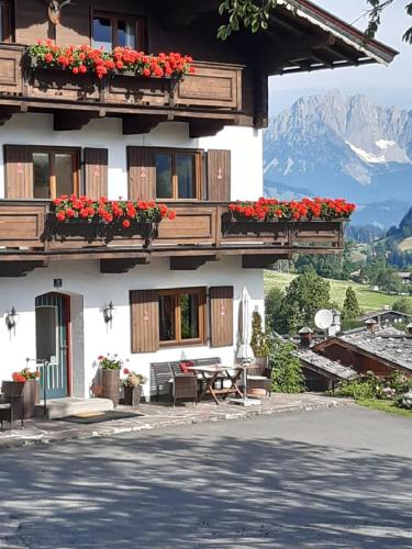 a building with flowers on the balconies and a table at Pension Feiersinger in Kitzbühel