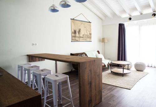 salon z drewnianym stołem i stołkami w obiekcie Apartamentos Estela de Altamira w mieście Santillana del Mar