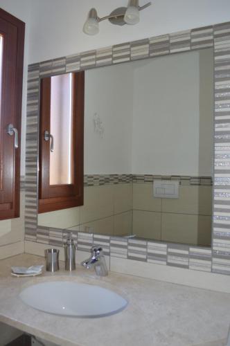 a bathroom with a sink, mirror, and bathtub at Guest Rooms Affittacamere in San Teodoro