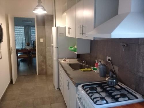 una cucina con piano cottura forno superiore accanto a un lavandino di Casino dos dormitorios a Mar del Plata