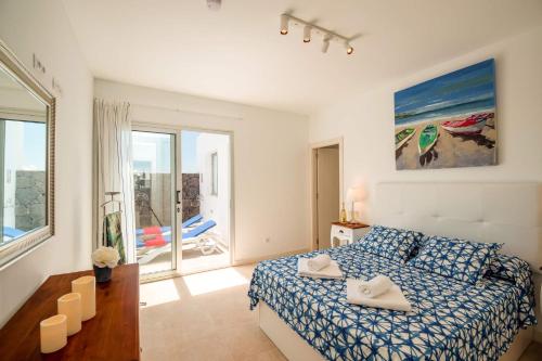 a bedroom with a bed and a room with a balcony at Villa Blue Horizon in Playa Blanca