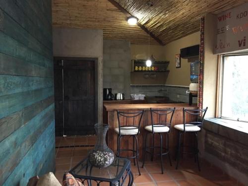 cocina con barra con taburetes y barra en Guest House Nativo - Charming, Cozy & Affordable, en Valle de Guadalupe
