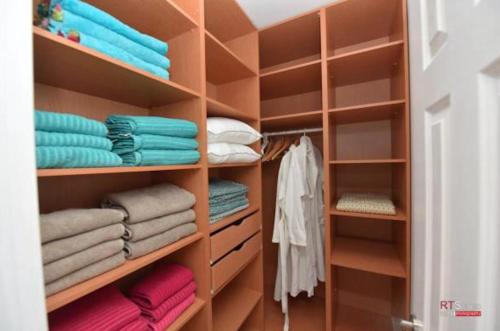 a closet filled with wooden shelves and towels at Villa with heated pool and Jacuzzi Sea View 300m Front of the Beach in Eilat
