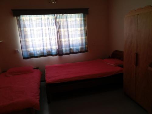 two beds in a small room with a window at Kilima Resort in Iten