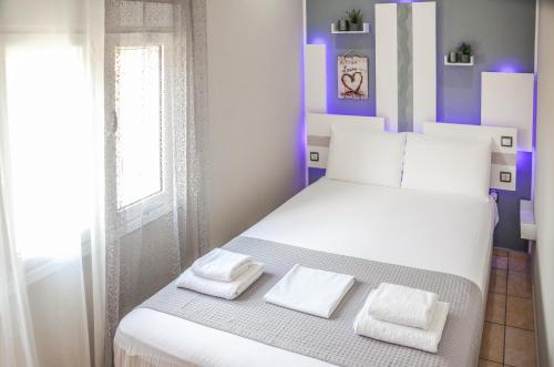 a bedroom with a white bed with two towels on it at Nina Apartment in Chania Town