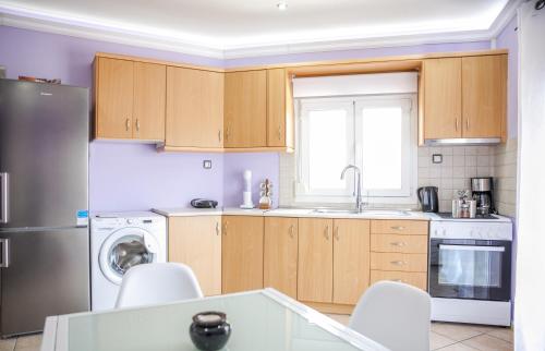 a kitchen with wooden cabinets and a stainless steel refrigerator at Nina Apartment in Chania Town