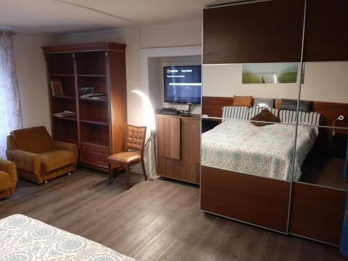 a bedroom with a bed and a chair and a television at Dogs baronesse Pasja grofica Idrija in Idrija