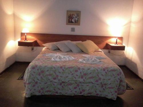 a bedroom with a large bed with two lamps on it at Pousada Moinho Azul in Teresópolis