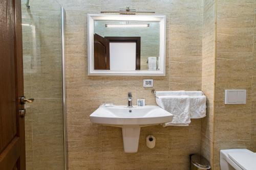a bathroom with a sink and a mirror at Poet Palace Bucharest in Bucharest
