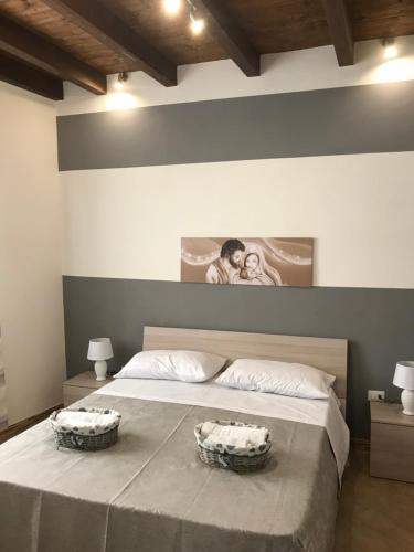 a bedroom with a large bed with two baskets on it at Casa Vacanze Antico Mercato in Marsala