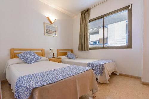une chambre avec deux lits et une fenêtre dans l'établissement Zeus Sant Jordi, à Salou