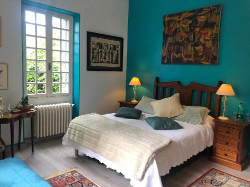 une chambre avec un grand lit aux murs bleus dans l'établissement Villa Aimée Luxury Apartments with Heated Pool, à Vals-les-Bains