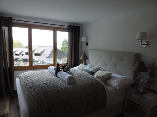 ein Schlafzimmer mit einem großen Bett und einem großen Fenster in der Unterkunft Chalet L'Escapade in Charmey