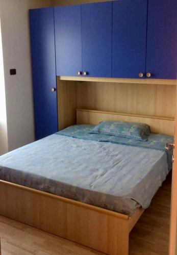 a bedroom with a wooden bed with blue cabinets at Casa nel centro di Cembra in Cembra