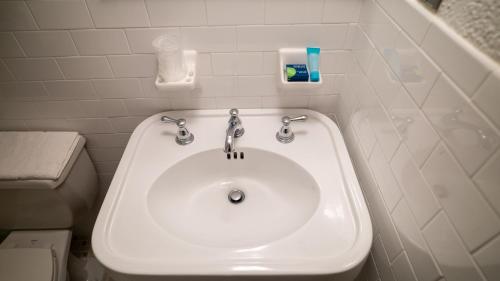 a bathroom with a white sink and a toilet at Holland Hotel Free Parking Jersey City in Jersey City