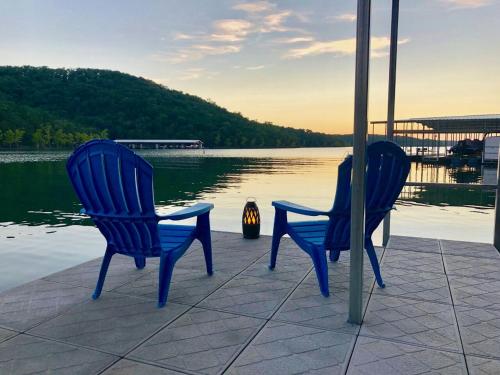 two blue chairs sitting next to a body of water at Table Rock Resorts at Indian Point in Branson
