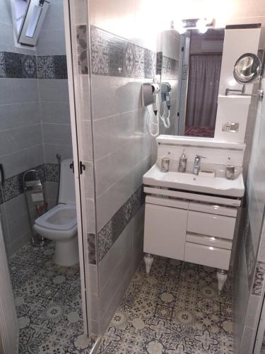 a bathroom with a sink and a toilet at Hotel LAHLOU riad Cafeteria in Oujda