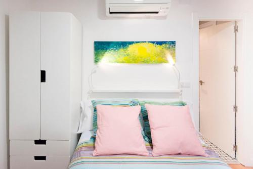 托萊多的住宿－SAN MARCOS，一间卧室配有带粉红色和蓝色枕头的床
