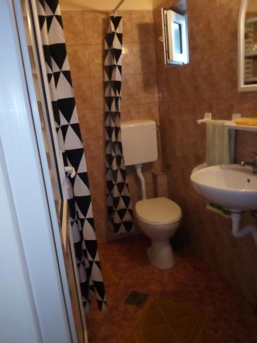 a small bathroom with a toilet and a sink at Casa OZZY&PATTY in 2 Mai