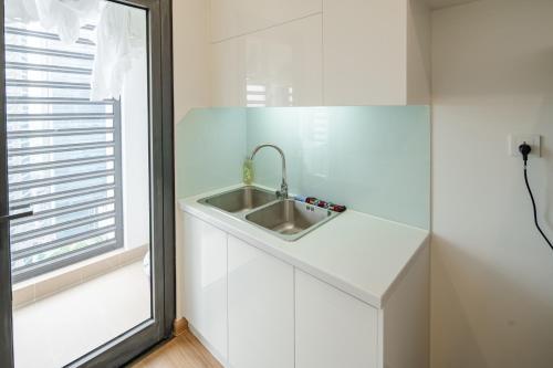 a white kitchen with a sink and a window at Luxury Apartment Vinhomes Skylake in Hanoi