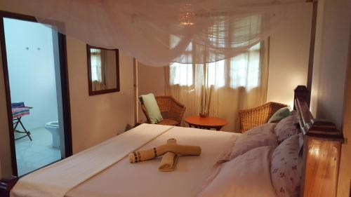 a bedroom with a bed with a wooden figurine on it at Casa Carlotta & Villa in Nungwi