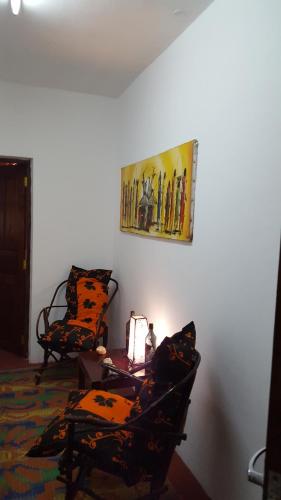 a room with two chairs and a painting on the wall at Casa Carlotta & Villa in Nungwi