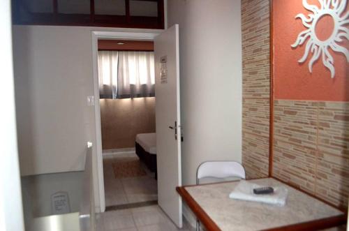 ein Zimmer mit einem Tisch und ein Zimmer mit einem Schlafzimmer in der Unterkunft Motel & Hotel Free Love JF in Juiz de Fora