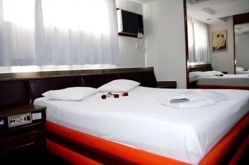 1 cama blanca grande en una habitación con ventana en Motel & Hotel Free Love JF en Juiz de Fora