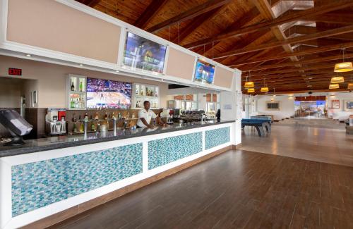 a restaurant with a bar with a pool at Viva Fortuna Beach by Wyndham, A Trademark All Inclusive in Freeport