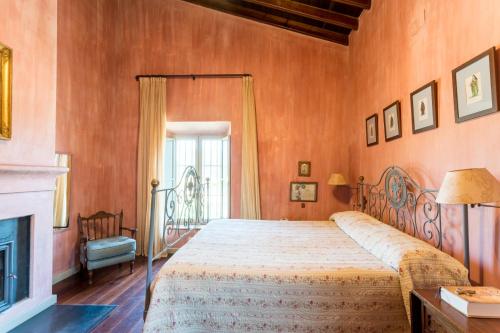 a bedroom with a bed and a fireplace at El Tejar in Zufre